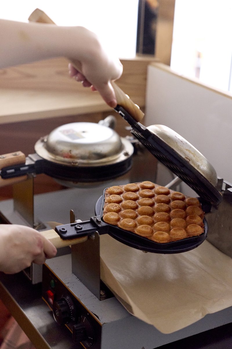 A bubble waffle being baked on the waffle iron